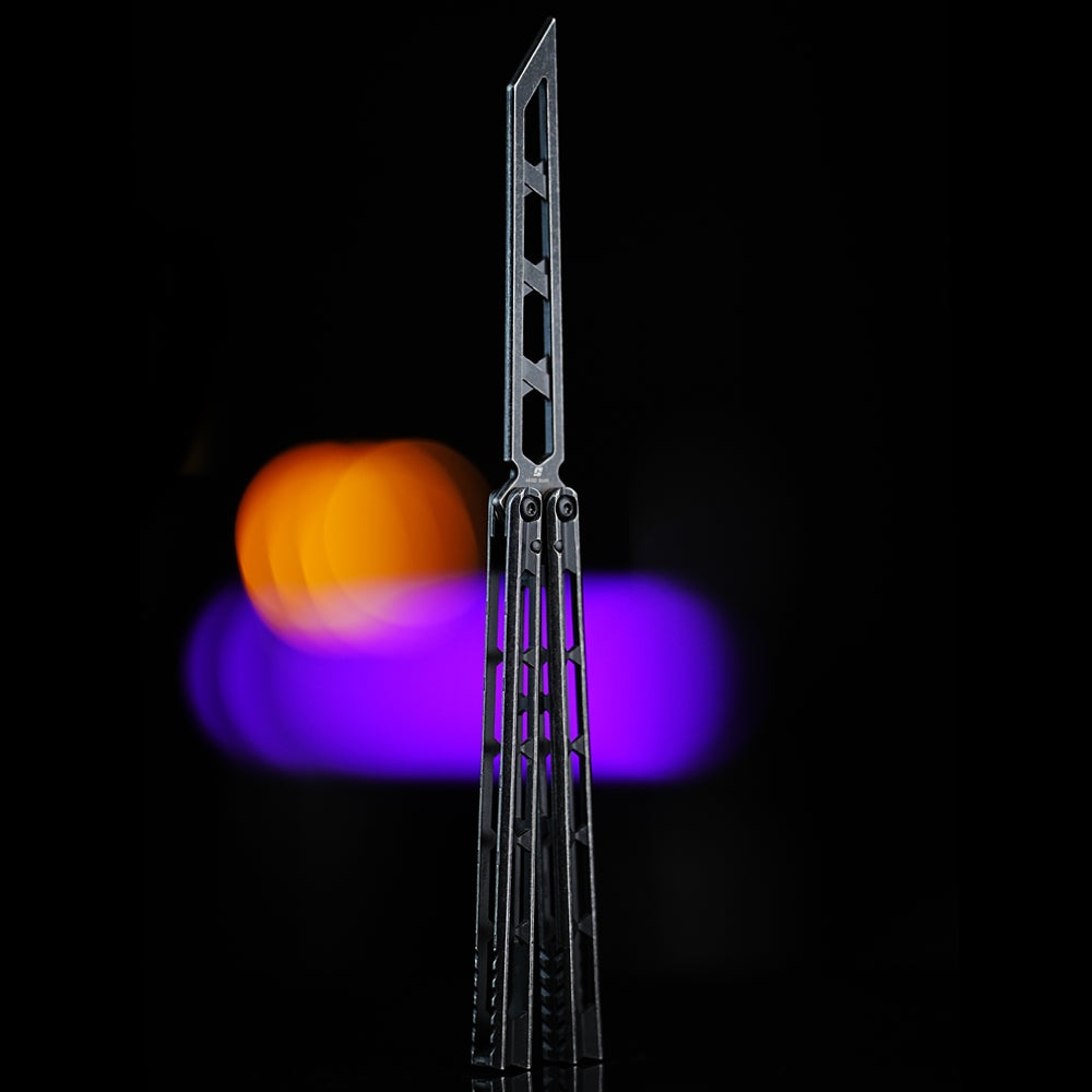 Armed Shark Prism Balisong Trainer in black color back view showing skeletonized stainless steel training edge and slim handle profile