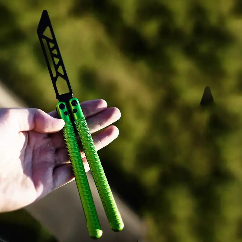 Alternate view of Armed Shark Sahara Butterfly Trainer with green aluminum handle held in hand outdoors