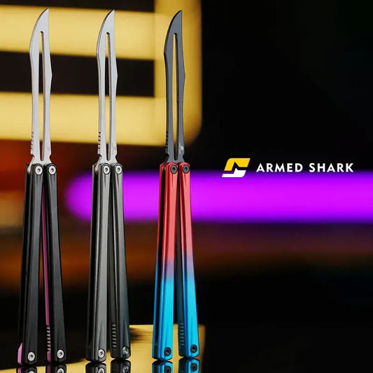 Front view of Armed Shark Eureka Balisong Trainer lineup in black, silver, and gradient red-blue finishes, showing polished stainless training edges and CNC-machined handles under studio lighting