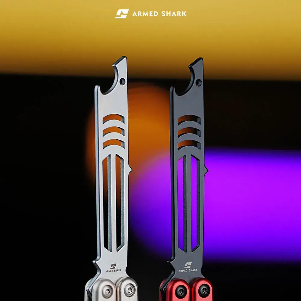 Close-up of Armed Shark Inked Mako bottle-opener training heads in silver and dark finishes, studio bokeh background.