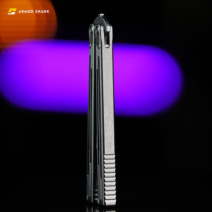 Armed Shark Titanium REP balisong trainer upright angled view with purple background light